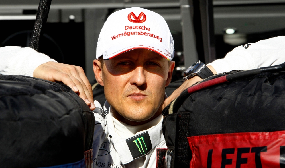 German Formula 1 driver Michael Schumacher leans between two tires on November 22, 2012 at the Interlagos racetrack in Sao Paulo, Brazil. Photo by ORLANDO KISSNER / AFP