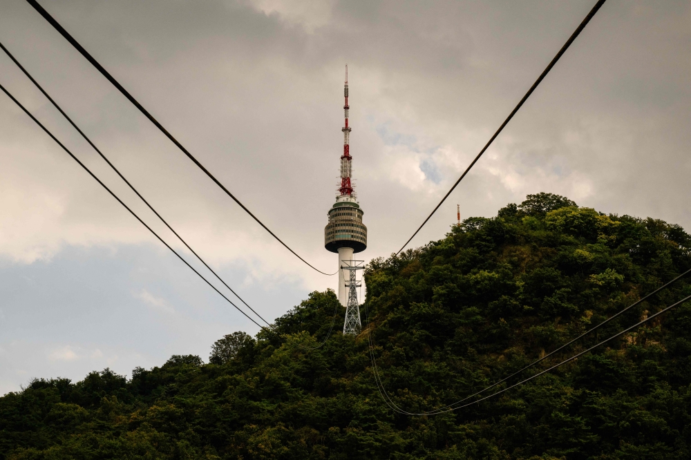 A general view taken from the Hoehyeon-dong platform shows the Namsan Tower and cables for the Namsan cable car in Seoul on September 25, 2024. (Photo by ANTHONY WALLACE / AFP)