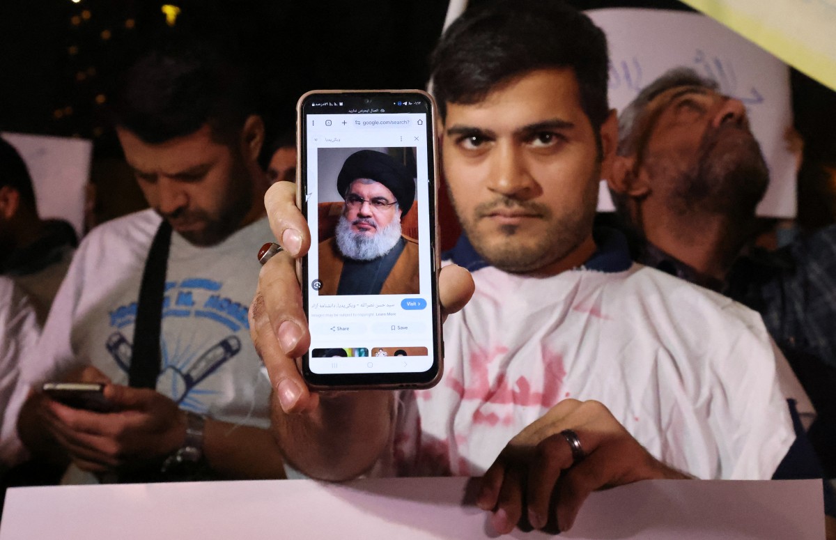 Photo used for demonstration purposes. A man shows a photo of Hassan Nasrallah, Secretary-general of Hezbollah, as people demonstrate against Israel and the attack on Lebanon at Palestine square in Tehran on September 28, 2024. Photo by ATTA KENARE / AFP.