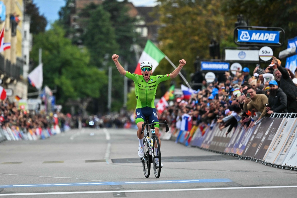 Slovenia's Tadej Pogacar celebrates as he crosses the finish line to win the men's Elite Road Race cycling event during the UCI 2024 Road World Championships, in Zurich, on September 29, 2024. (Photo by Fabrice Coffrini / AFP)