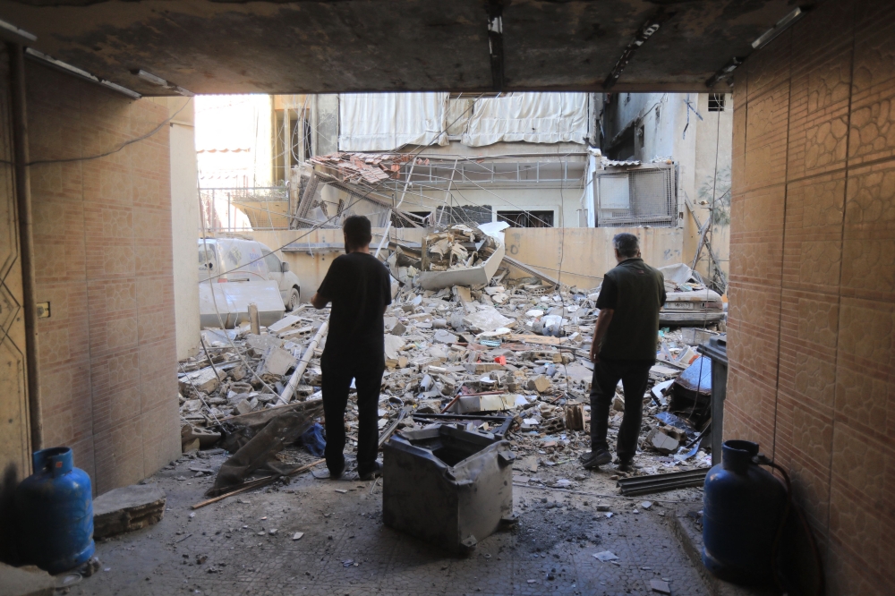 People inspect the damage at the site of an overnight Israeli strike on Beirut's southern suburb of Ghobeiry on September 30, 2024. (Photo by AFP)