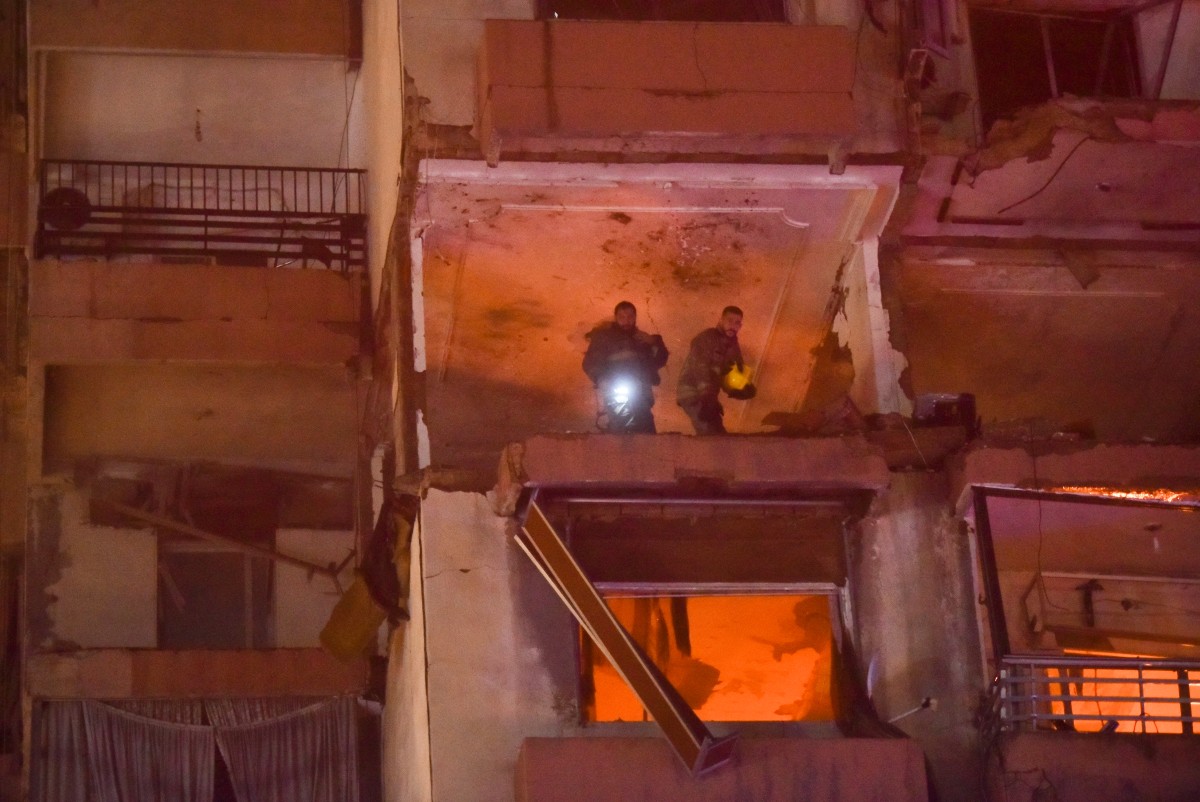 Firefighters search for survivors inside an apartment building hit by an Israeli air strike in Beirut's Cola district, September 30, 2024. Photo by Fadel ITANI / AFP.