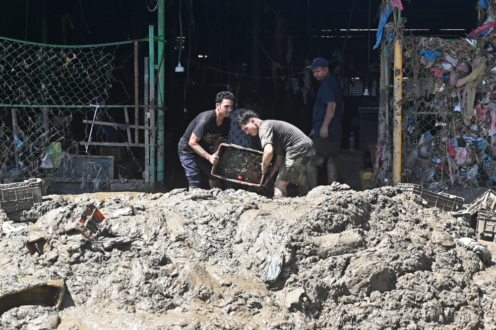 Vendors clear mud from a vegetable market in a flood-affected area following heavy monsoon rains in Kathmandu on September 30, 2024. Photo by Prakash MATHEMA / AFP