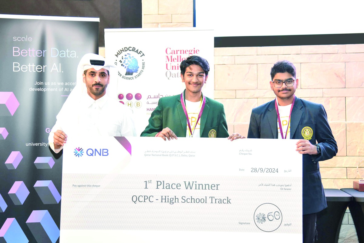 A QNB official presenting award to QCPC 2024 winners in high school track competition.