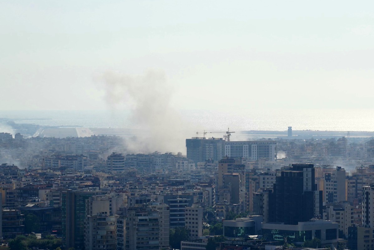 Smoke rises above buildings in Beirut's southern suburbs following an Israeli strike, on October 4, 2024. Photo by ETIENNE TORBEY / AFP.