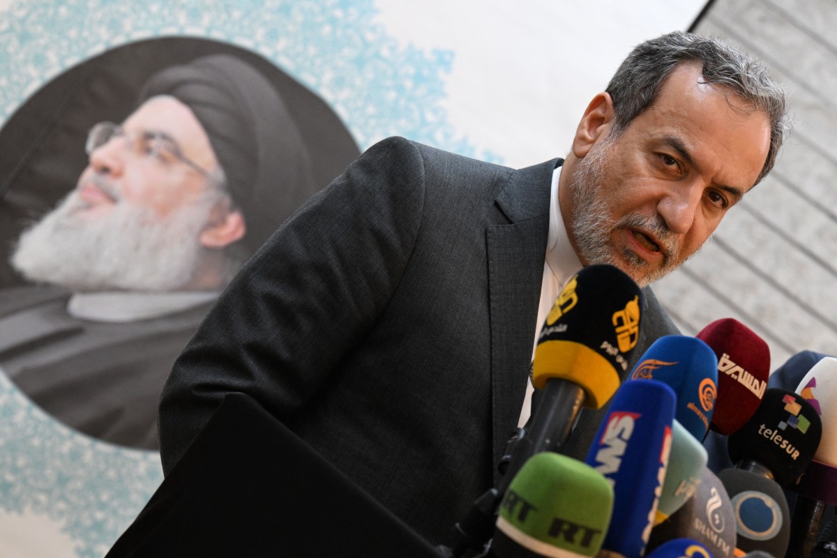 Iranian Foreign Minister Abbas Araghchi speaks to the press, in front of the portrait of slain Lebanese Hezbollah leader Hassan Nasrallah, after meeting with Syrian officials at the Iranian embassy in Damascus on October 5, 2024. Photo by LOUAI BESHARA / AFP.