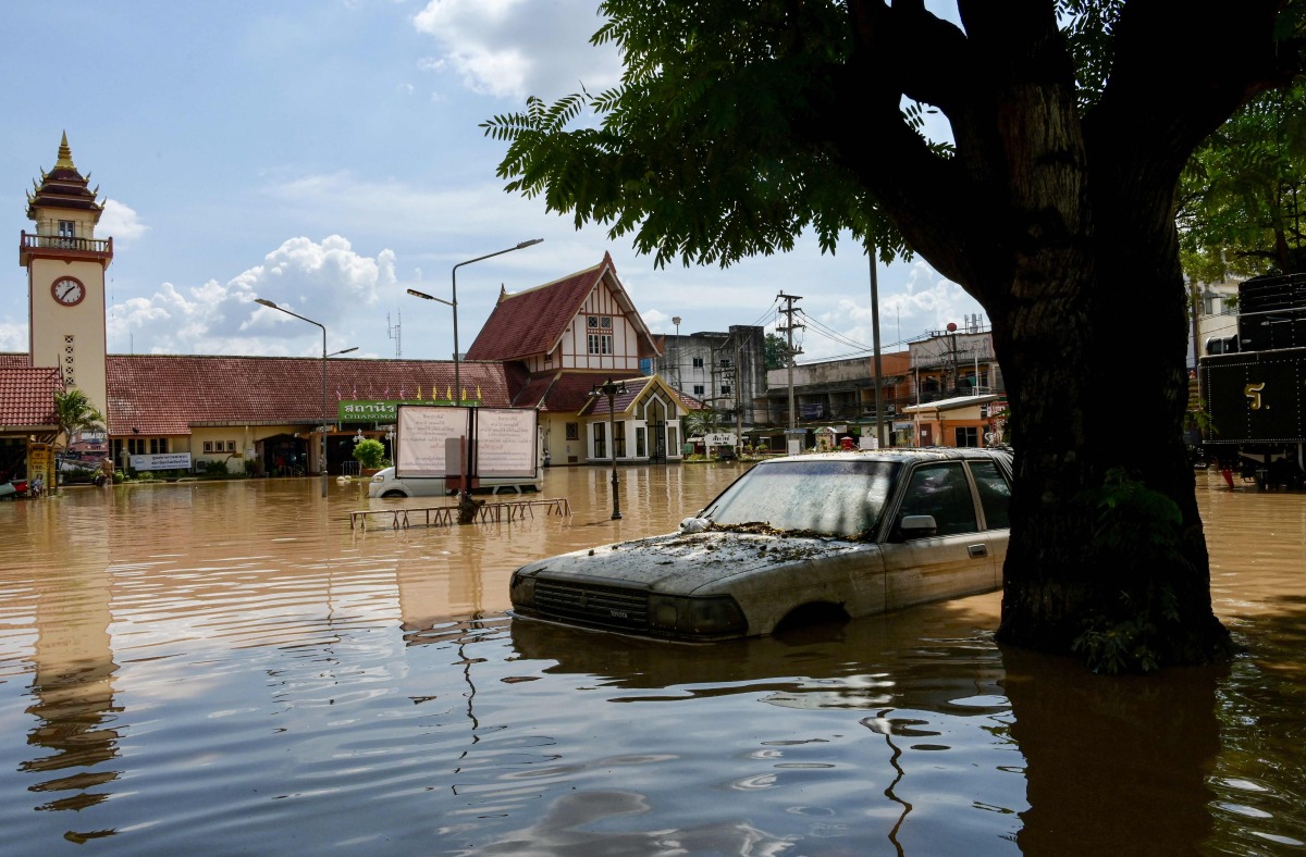 A car is submerged in flood waters in front of the central train station in Chiang Mai, on October 6, 2024. (Photo by AFP)
