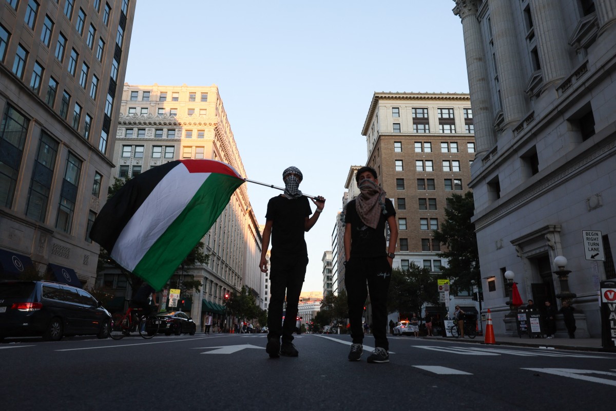 Photo used for demonstration purposes. A demonstrator holds a Palestinian flag as people march to mark one year of the war on Gaza, in Washington, DC on October 5, 2024. Photo by Ting Shen / AFP.
