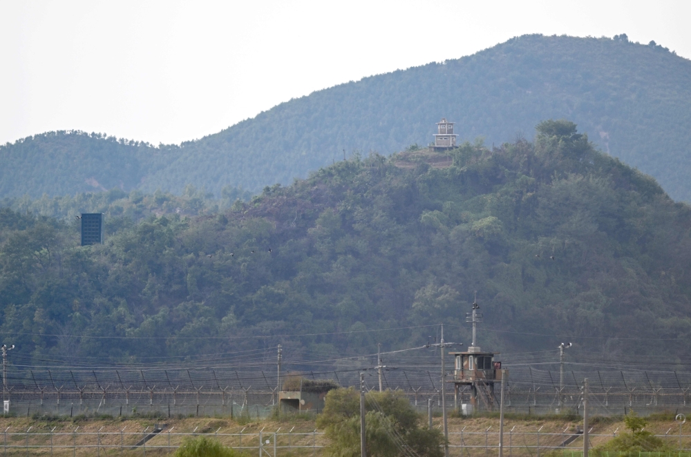 A North Korean guard post (R top) and a loudspeaker (L) on the North side of the Demilitarized Zone (DMZ) dividing the two Koreas, are seen over a South Korean guard post (bottom) from the border city of Paju on October 9, 2024. (Photo by Jung Yeon-je / AFP)
 