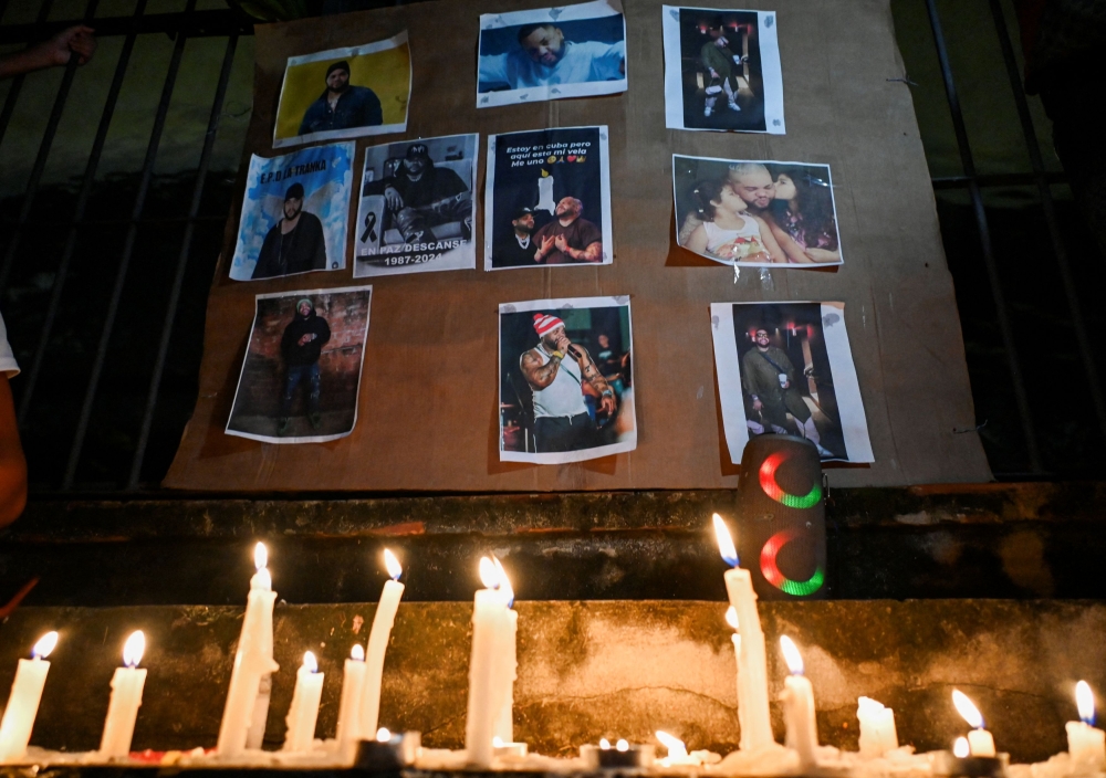 Cubans light candles next to pictures of late reggaeton singer Jose Manuel Carbajal (El Taiger) as they pay tribute in Havana on October 10, 2024. Photo by YAMIL LAGE / AFP