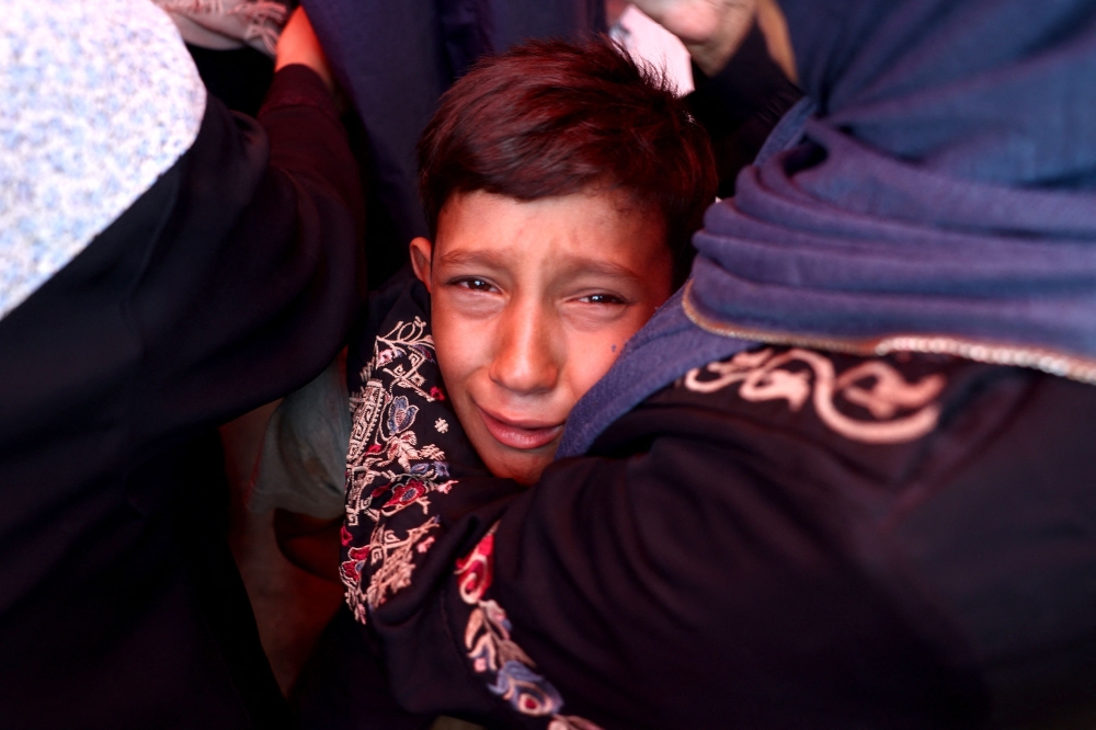 A Palestinian boy cries after an Israeli strike hit the Rafida school housing displaced people in Deir al-Balah in the central Gaza Strip on October 10, 2024.(Photo by Eyad Baba / AFP)