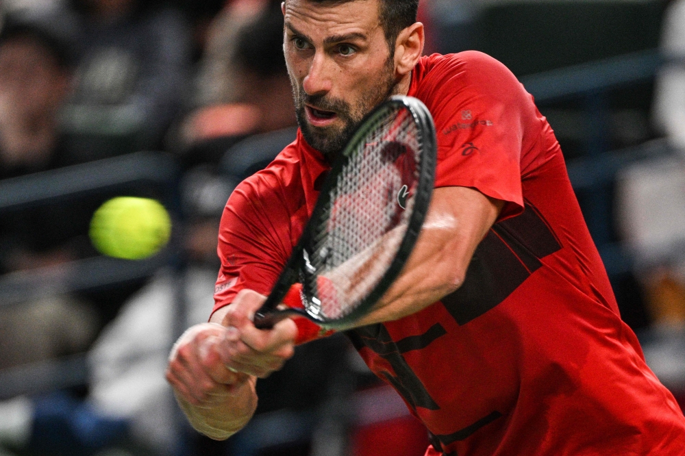 Serbia's Novak Djokovic hits a return to Italy's Jannik Sinner during their men's singles final match at the Shanghai Masters tennis tournament in Shanghai on October 13, 2024. (Photo by Hector Retamal / AFP)