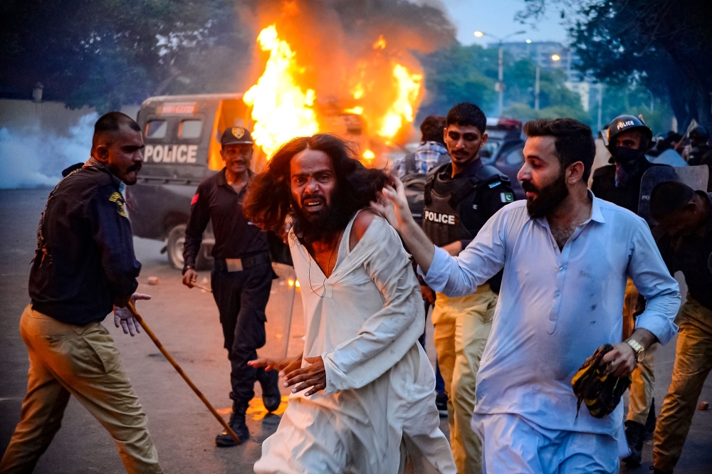 Police detain a Tehreek-e-Labbaik Pakistan (TLP) party member during a protest in Karachi on October 13, 2024. (Photo by Qaisar Khan / AFP)