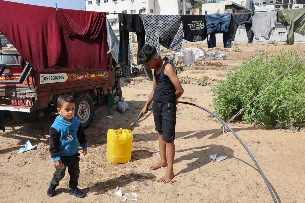 Children at a makeshift camp for Palestinians displaced from northern Gaza, at Gaza City's Yarmouk stadium on October 14, 2024. (Photo by Omar Al-Qattaa / AFP)