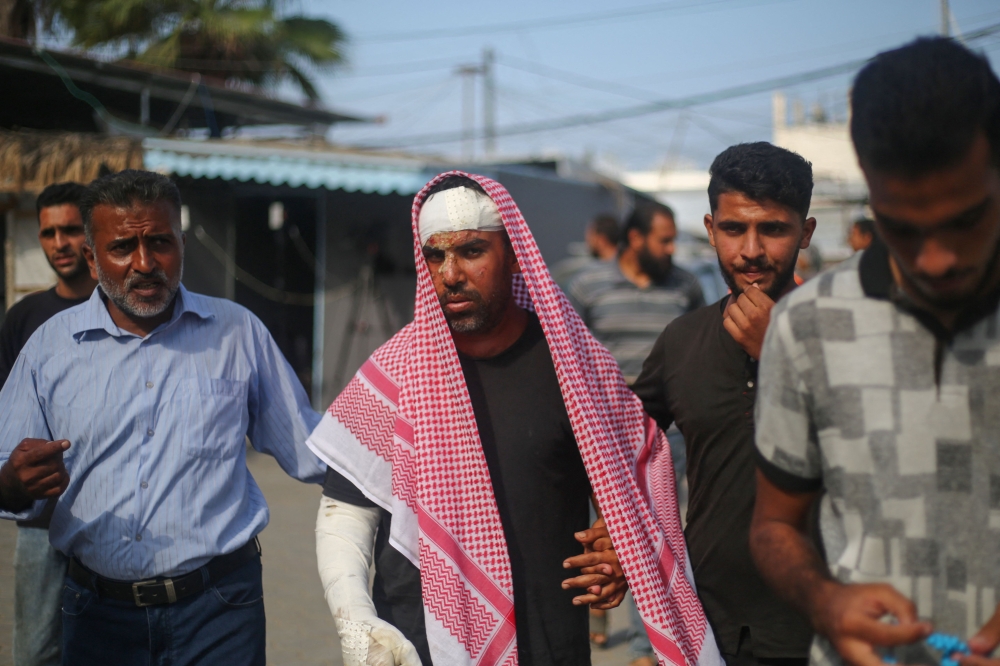 Injured Palestinian Ahmed al-Dalu, who survived an Israeli airstrike on tents for displaced people two days earlier which killed his wife and son Shaaban in the courtyard of Al-Aqsa Martyrs Hospital, walks in front of the medical facility in Deir al-Balah in the central Gaza Strip, on October 16, 2024. (Photo by Eyad BABA / AFP)