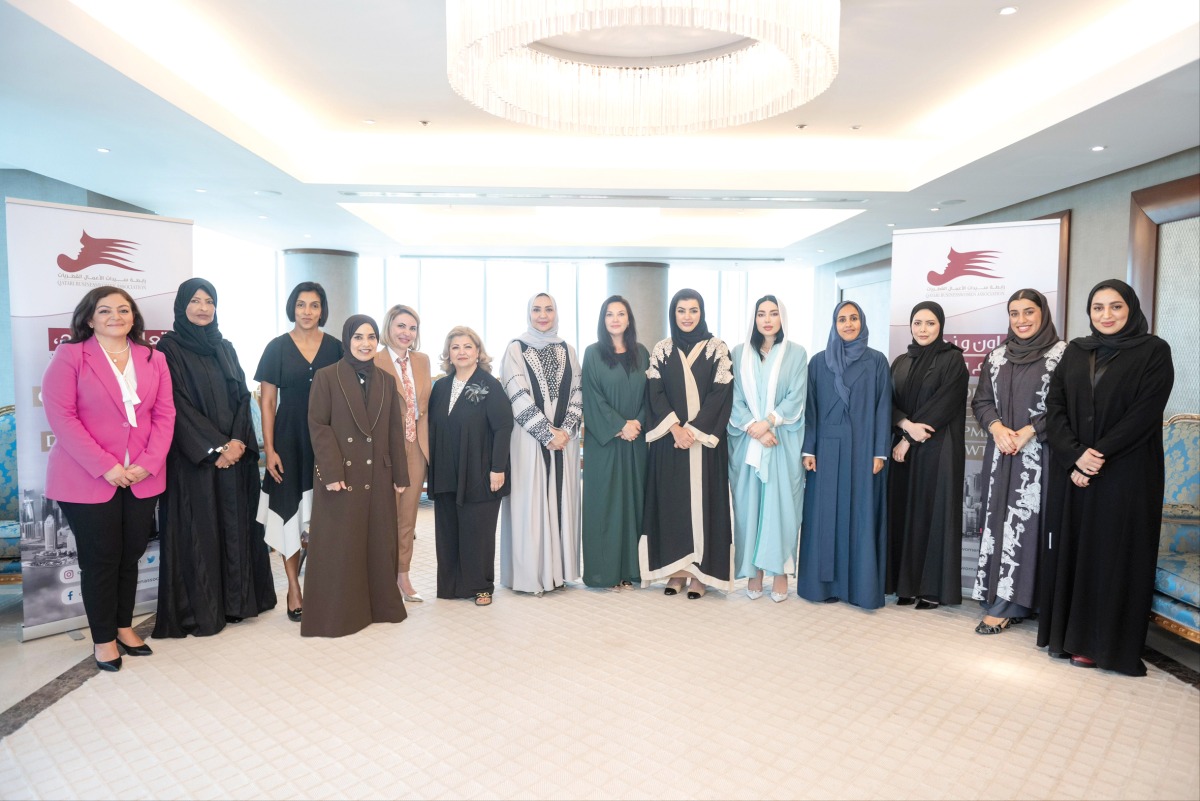 QBWA Vice Chairwoman Aisha Alfardan and EWA Founder and President Yulia Stark pose for a group photo with other officials.