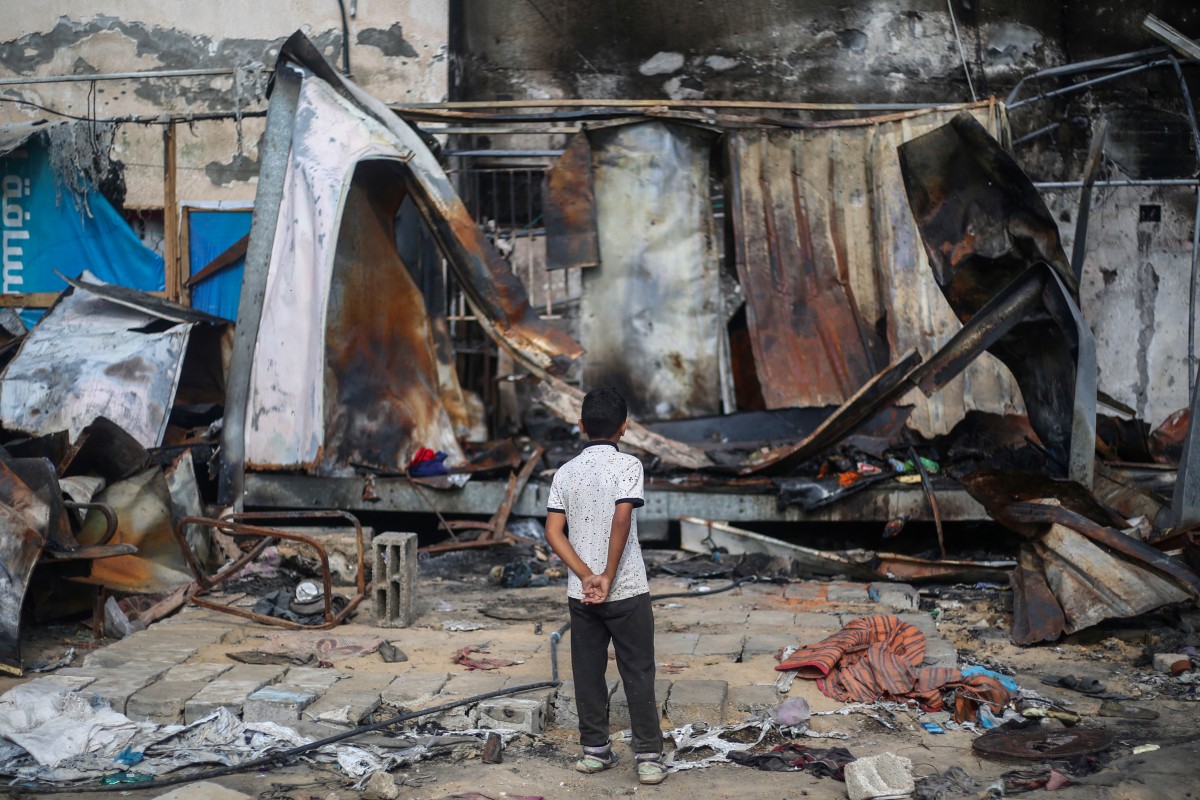 A Palestinian boy looks at destroyed shelters at the site of an Israeli airstrike which hit tents for displaced people two days earlier in the courtyard of Al-Aqsa Martyrs Hospital in Deir al-Balah in the central Gaza Strip on October 16, 2024. Photo by Eyad BABA / AFP.