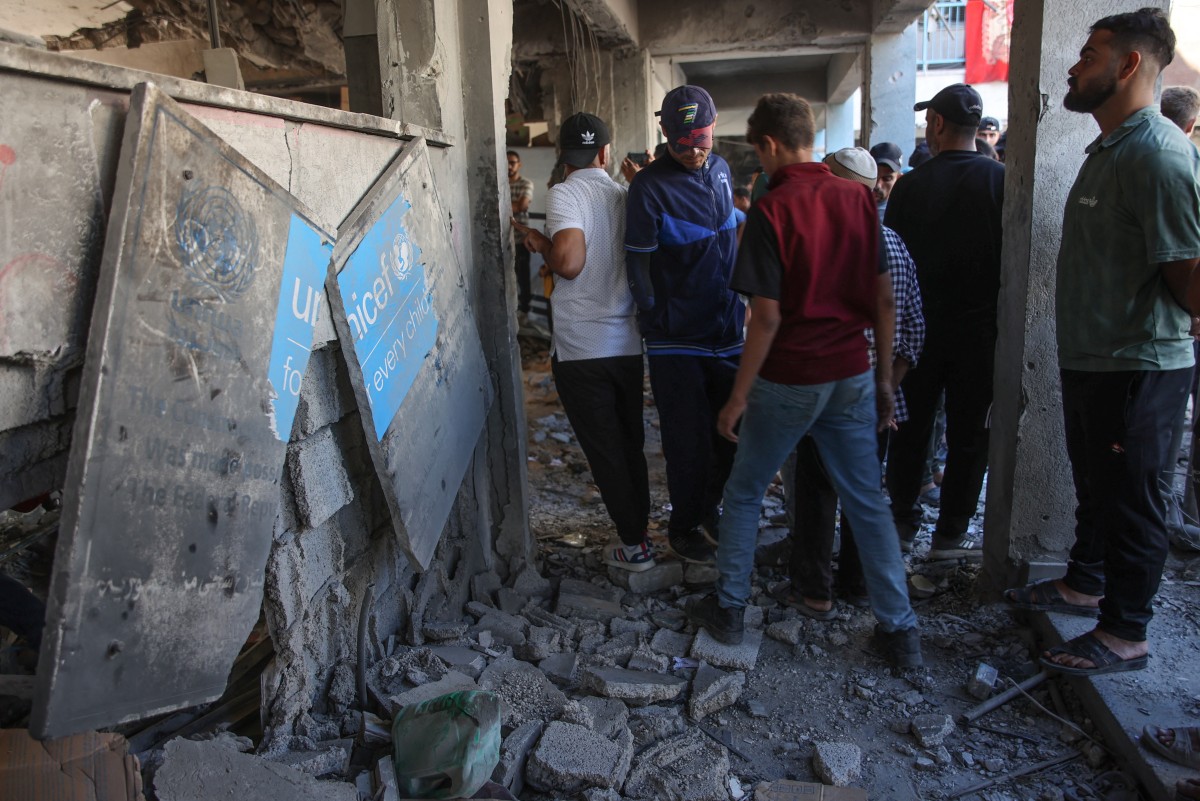 Displaced Palestinians check the damage inside UN school-turned-refuge in the Al-Shati refugee camp near Gaza City in the northern Gaza Strip, following a reported Israeli strike on October 19, 2024. Photo by Omar AL-QATTAA / AFP.
