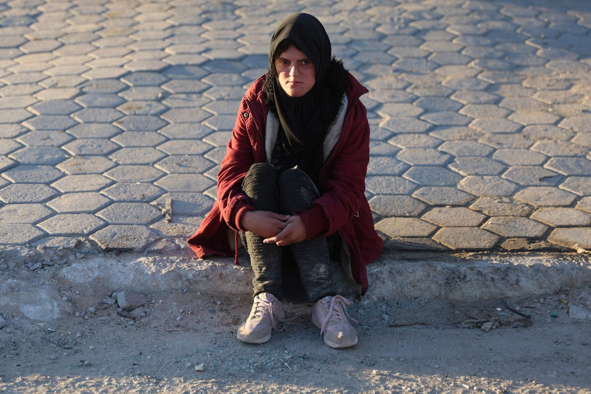 A displaced Palestinian, ordered by the Israeli occupation army to leave the school in Beit Lahia where they were sheltered, rests as she arrives in Gaza City on October 19, 2024. (Photo by Omar AL-QATTAA / AFP)
