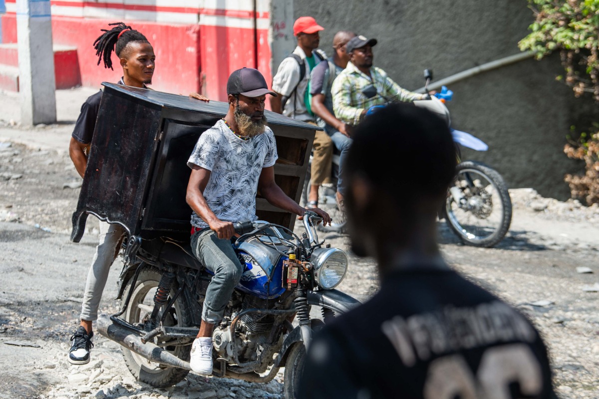 People flee their neighborhood after armed gangs terrorized the Delmas 24 and Solino areas, in Port-au-Prince, Haiti, October 20, 2024. (Photo by Clarens SIFFROY / AFP)
