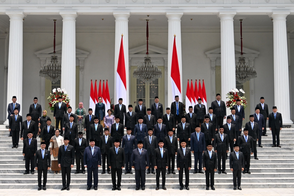 Indonesia's President Prabowo Subianto (front centre L) and Vice President Gibran Rakabuming Raka (front centre R) pose with newly sworn-in cabinet ministers in front of the Presidential Palace in Jakarta on October 21, 2024. (Photo by Bay Ismoyo / AFP)