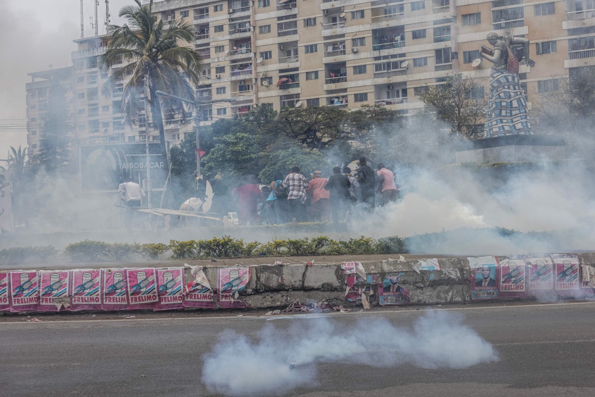 \Supporters of the Optimist Party for the Development of Mozambique (PODEMOS) run from tear gas lobbed at them by units of the Mozambican anti-riot police during a strike called in Maputo, on October 21, 2024. (Photo by ALFREDO ZUNIGA / AFP)
