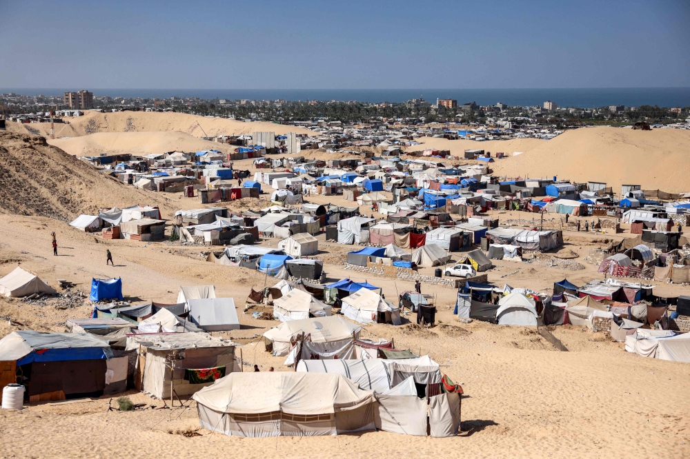 Tents sheltering people displaced by conflict are pictured with the Mediterranean sea in the background in the Mawasi area of Khan Yunis in the southern Gaza Strip on October 23, 2024. (Photo by Bashar Taleb / AFP)