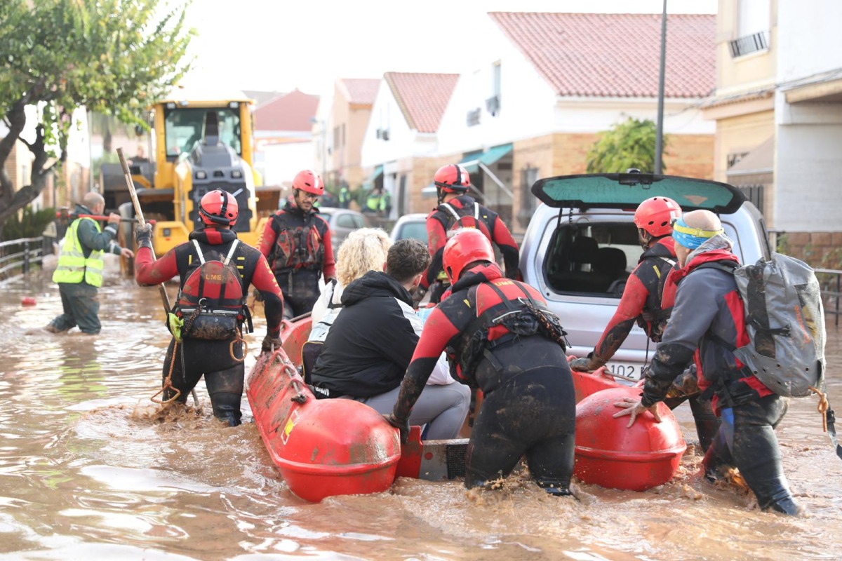 This handout photo taken by the UME - Spanish Military Emergencies Unit shows Spanish rescuers taking residents on a dinghy boat following deadly flooding, in Valencia, on October 30, 2024. (Photo by Handout / UME / AFP)
