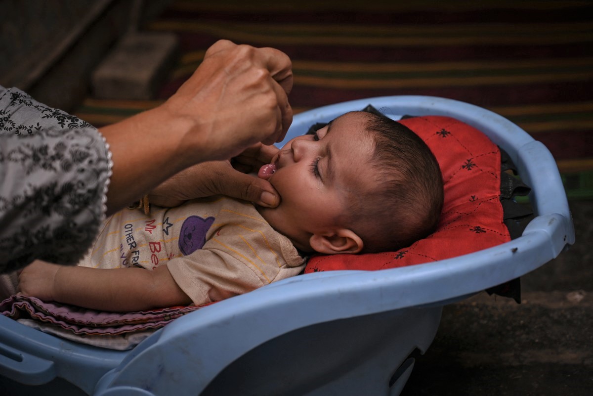 A health worker administers polio drops to a child during a door-to-door vaccination campaign in Karachi on October 28, 2024. Photo by Rizwan Tabassum / AFP.

