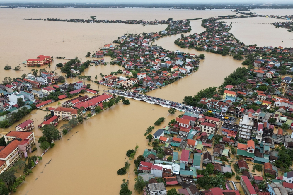 This aerial photo taken on October 29, 2024 shows cars parked on a bridge to avoid flood waters in Quang Binh province in central Vietnam. Photo by An Xa / AFP