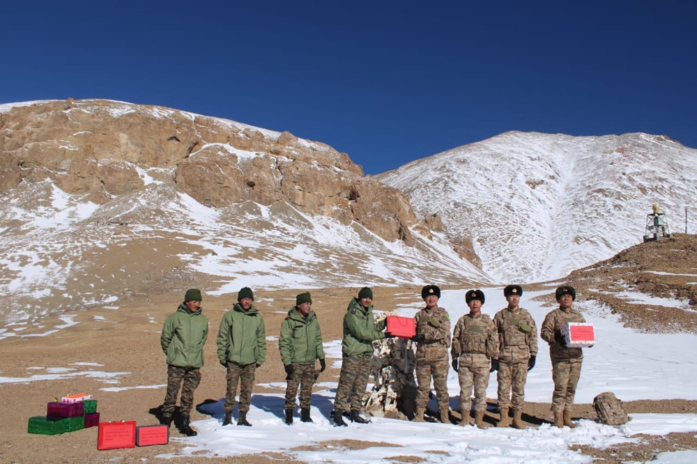 Indian and Chinese army greet each other along the Line of Actual Control (LAC) near Karakoram pass in Ladakh on October 31, 2024. (Photo by Indian Army / AFP) 