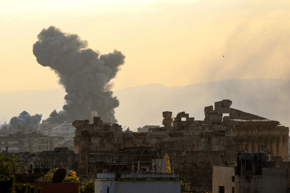 Smoke rises from the site of an Israeli airstrike that targeted an area on the outskirts of the eastern Lebanese city of Baalbeck in the Bekaa valley on October 31, 2024. In the foreground the ancient Roman ruins with the Temple of Bacchus can be seen. (Photo by Nidal Solh / AFP)