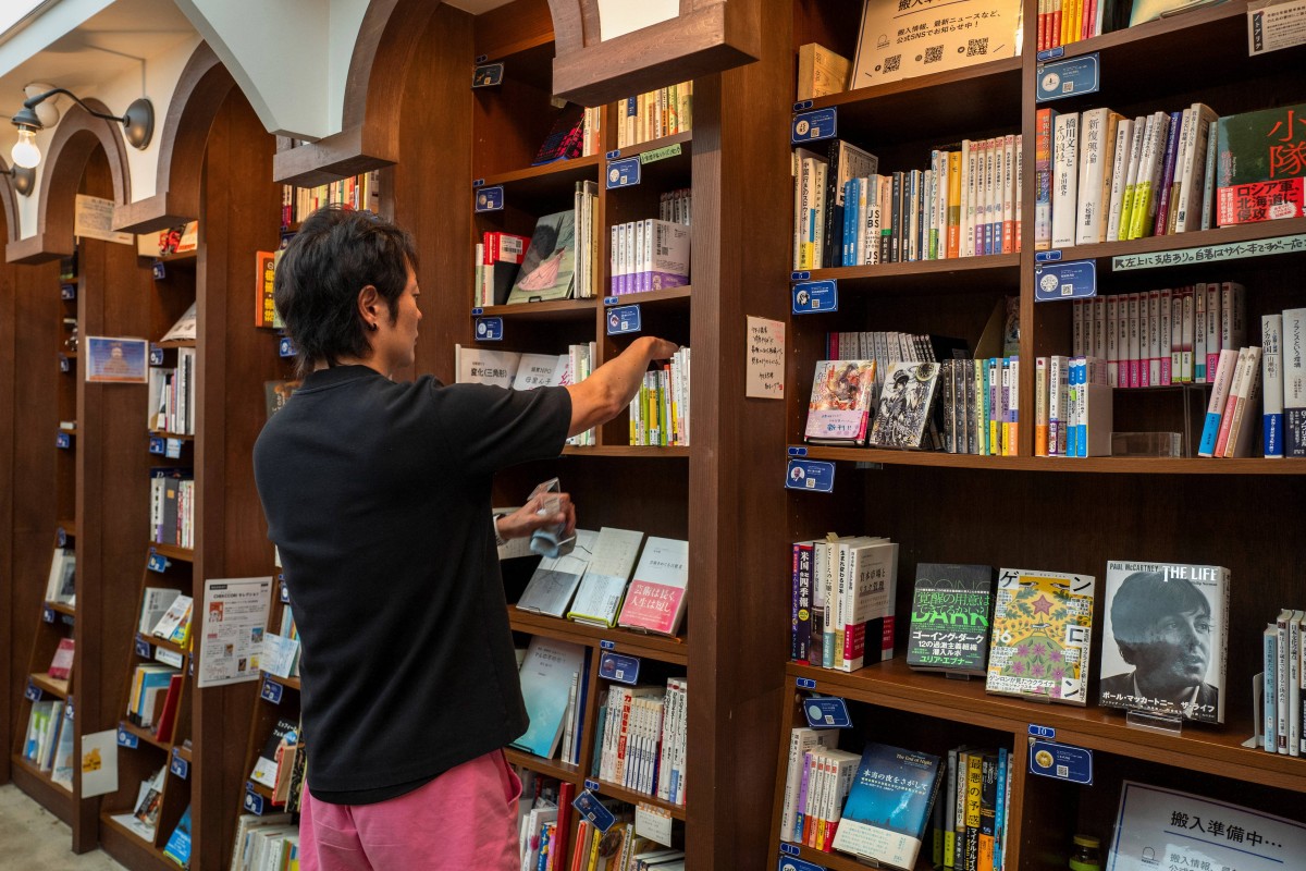 This photo taken on August 1, 2024 shows Rokurou Yui, president of book review site All Reviews and president of three shelf-sharing bookstores, working at his bookstore in Tokyo's Kanda Jimbocho district, one of the world's largest 