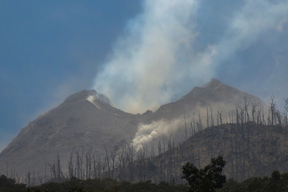 Smoke rises from Mount Lewotobi Laki-Laki as seen Klatanlo village, in East Flores Regency, East Nusa Tenggara, on November 4, 2024, after it erupted overnight. (Photo by Arnold Welianto / AFP)