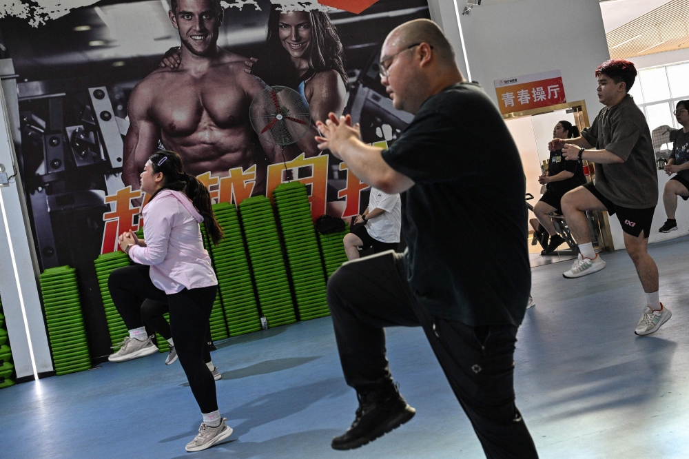 This photo taken on October 23, 2024 shows people exercising at a weight loss camp in Chengdu, in China's southwestern Sichuan province.  (Photo by Hector Retamal / AFP) 