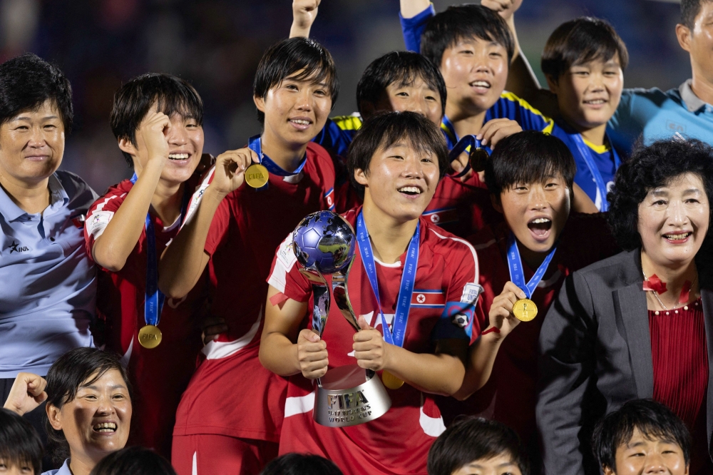 North Korea's players celebrate with the trophy after winning the FIFA U-17 women's football World Cup 2024 final match between North Korea and Spain at the Olimpico Felix Sanchez Stadium in Santo Domingo on November 3, 2024. (Photo by Nelson Pulido / AFP)