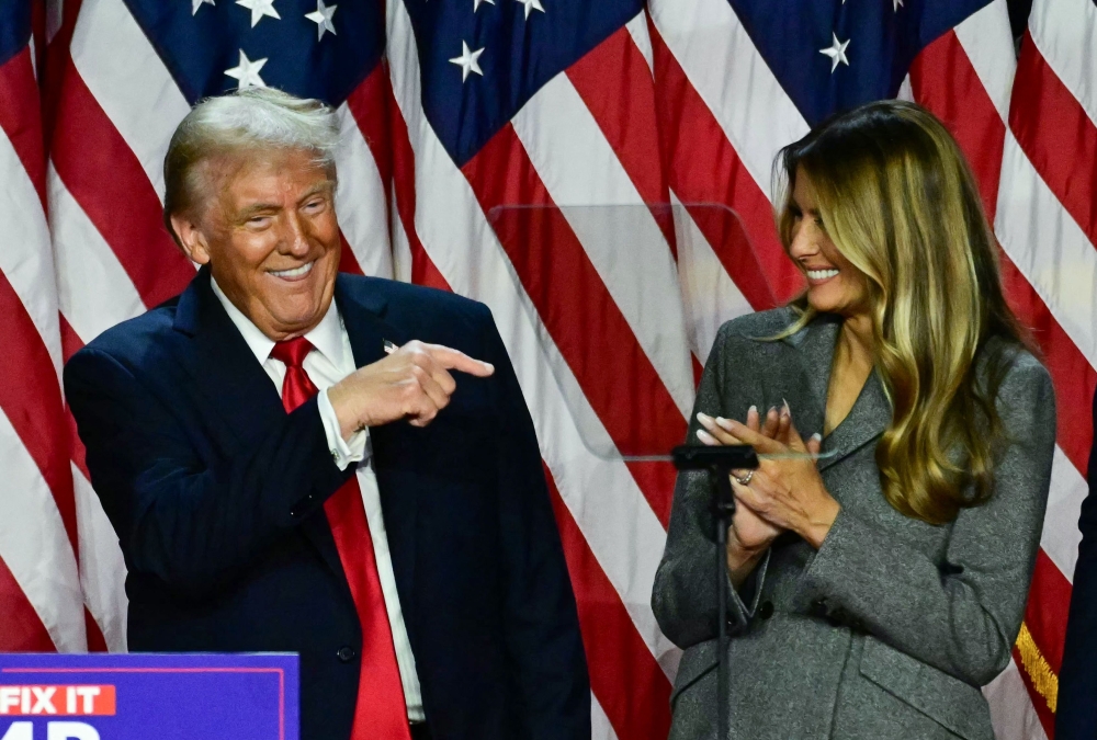 Former US President and Republican presidential candidate Donald Trump points to his wife former US First Lady Melania Trump during an election night event on November 6, 2024. (Photo by Jim Watson / AFP)