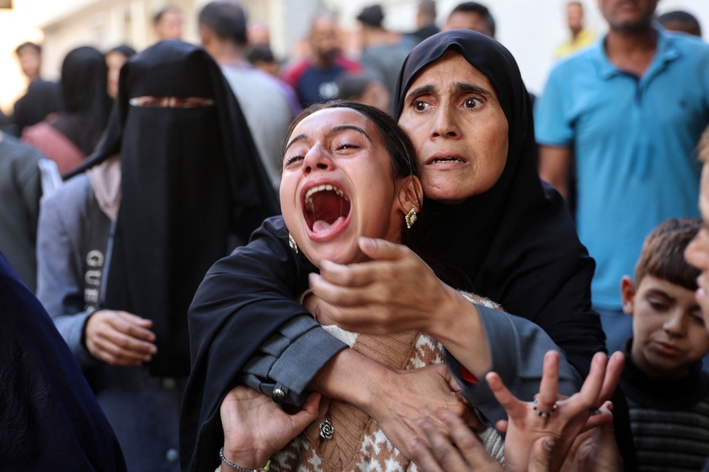 A young Palestinian girl reacts in the courtyard of the al-Shifa hospital in Gaza City after the bodies of victims were transported there, following an Israeli strike that hit a school-turned-shelter in the Al-Shati refugee camp on November 7, 2024. (Photo by Omar Al-Qatta / AFP)