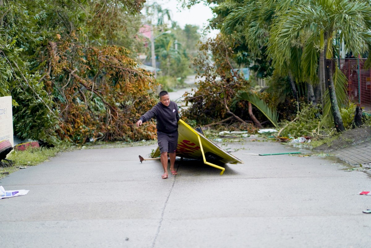 In this handout photo from Nathan Tamayo taken and received on November 8, 2024, a man picks up a debris in the aftermath of Typhoon Yinxing in Ballesteros, province of Cagayan. (Photo by Nathan Tamayo / AFP)