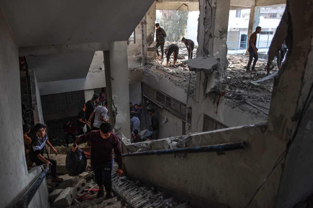 Palestinians check the damage inside a UN school-turned-shelter following an Israeli strike in the Al-Shati refugee camp on November 7, 2024. (Photo by Omar Al-Qattaa / AFP)