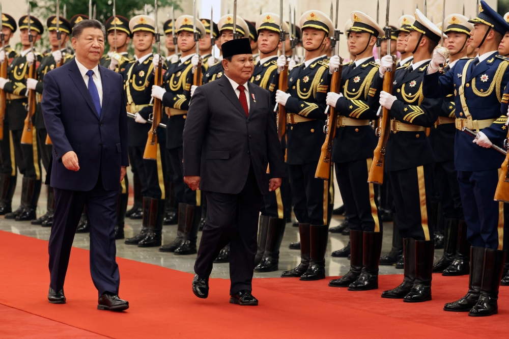 Chinese President Xi Jinping (L) and Indonesian President Prabowo Subianto review the honour guard during a welcome ceremony at the Great Hall of the People in Beijing on November 9, 2024. (Photo by Florence Lo / Pool / AFP)