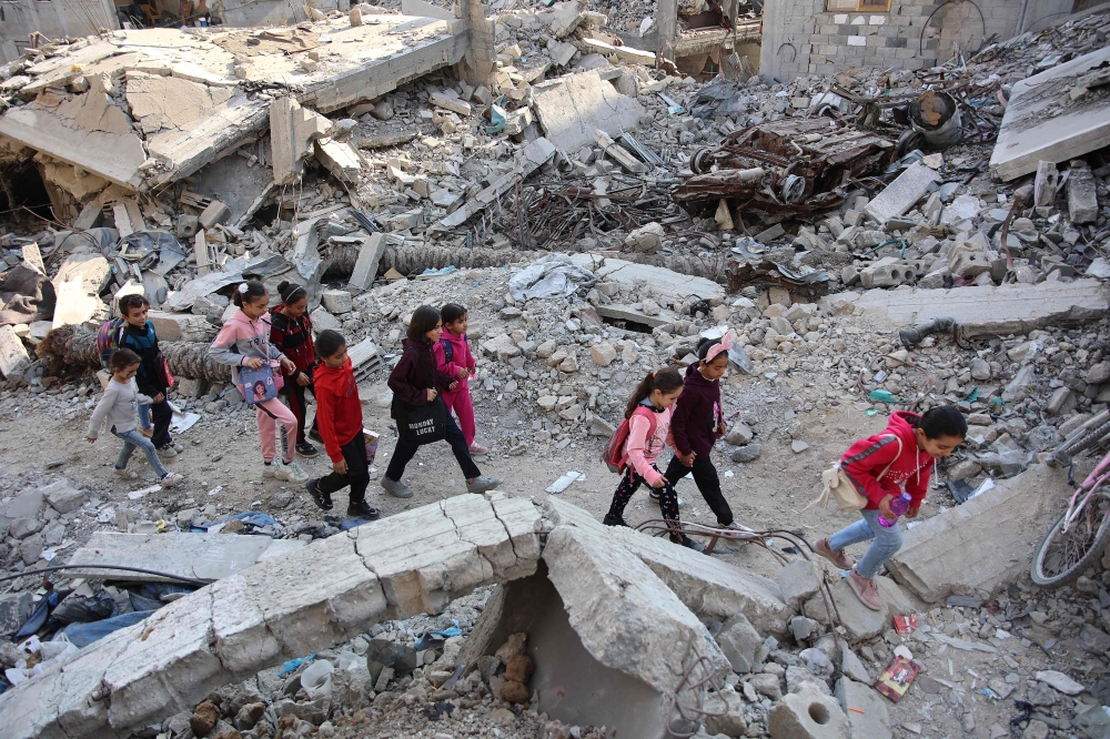 Palestinian girls walk above the rubble of a building destroyed in previous Israeli bombardment, in Gaza City on November 9, 2024. (Photo by Omar AL-QATTAA / AFP)