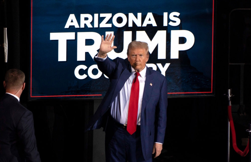 (Files) Former US President and Republican presidential candidate Donald Trump waves as he leaves after speaking during a campaign event at the Tucson Music Hall in Tucson, Arizona, September 12, 2024. (Photo by Rebecca Noble / AFP)