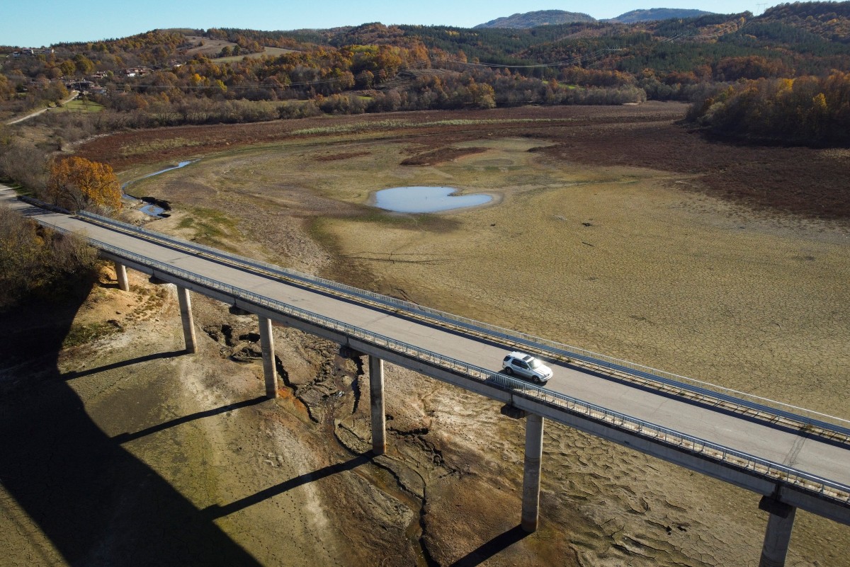 Photo used for demonstration purposes. A car rides by the dried Yovkovtsi dam, near the town of Elena, Central Bulgaria on November 08, 2024. Nine of 12 dams supplying water to localities in Bulgaria are 65% full, and the drought in summer is perduring now in the autumn. More than 240.000 people in a country of 6,5 million are facing regular water shortages. Photo by Nikolay DOYCHINOV / AFP.