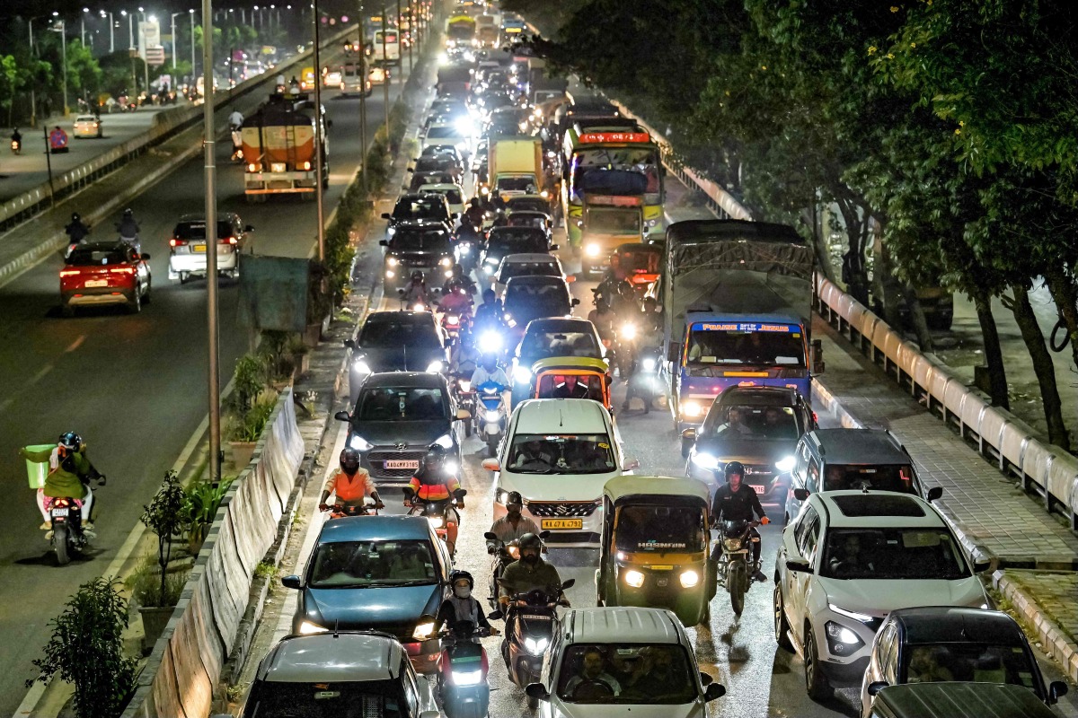 Commuters wait in a traffic jam during rush hour along a street in Bengaluru on November 12, 2024. (Photo by Idrees MOHAMMED / AFP)