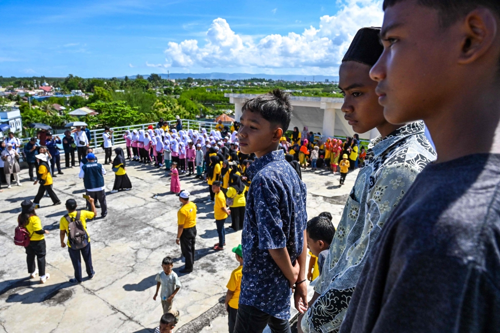 People take part in an earthquake and tsunami drills ahead of the 20-year anniversary of the Boxing Day disaster in Banda Aceh on November 13, 2024. (Photo by CHAIDEER MAHYUDDIN / AFP)