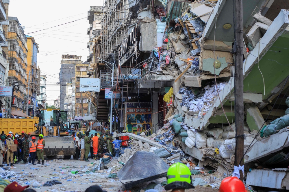 Emergency crews and first responders gather for rescue operations at the site of a collapsed four-story building in Dar es Salaam on November 16, 2024. (Photo by Gidulaus Amosi / AFP)