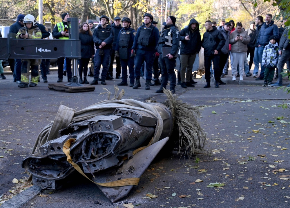 People look at the remains of a downed Russian hypersonic missile Zircon, after it struck a five-storey residential building in Kyiv during a 