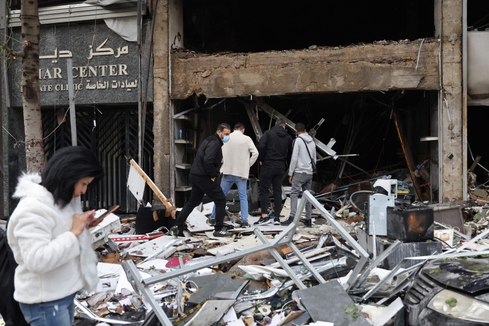 People inspect the damage to a building, targeted in an Israeli airstrike the previous day, in Beirut's Mar Elias Street on November 18, 2024. (Photo by Anwar Amro / AFP)