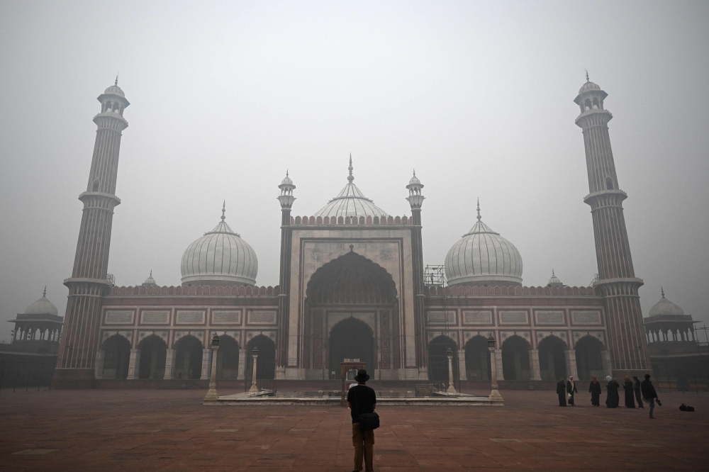 Tourists visit Jama Masjid amid thick smog, in the old quarters of Delhi on November 18, 2024. (Photo by Sajjad Hussain / AFP)